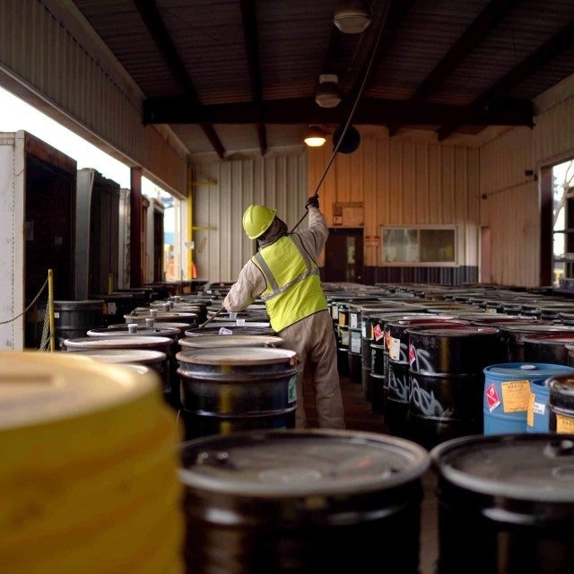 hazardous-barrels-in-row-man-in-ppe