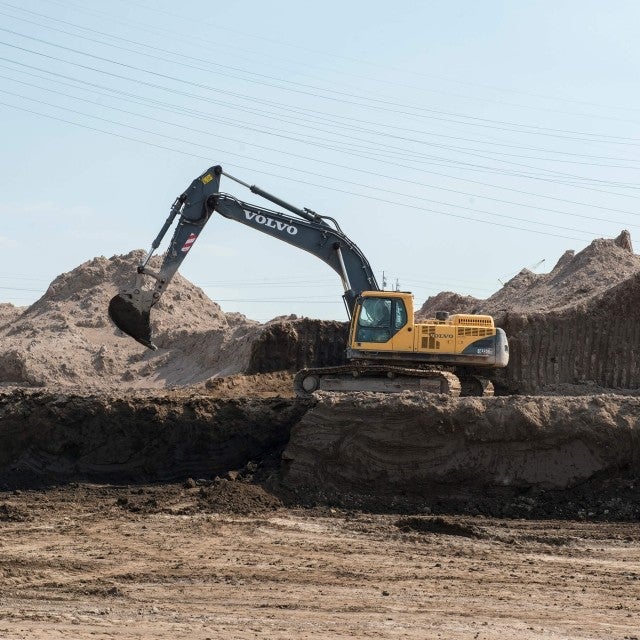 Excavator moving dirt on work site 