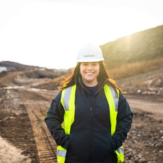woman standing and smiling at soil work site