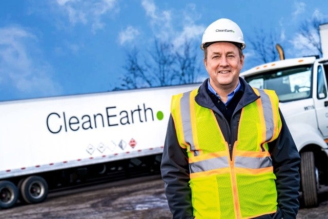 Man in safety gear standing in front of semi truck