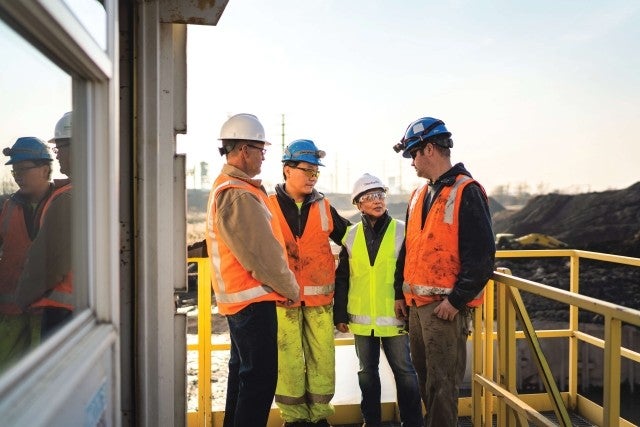 team members meeting on balcony at dredge site 